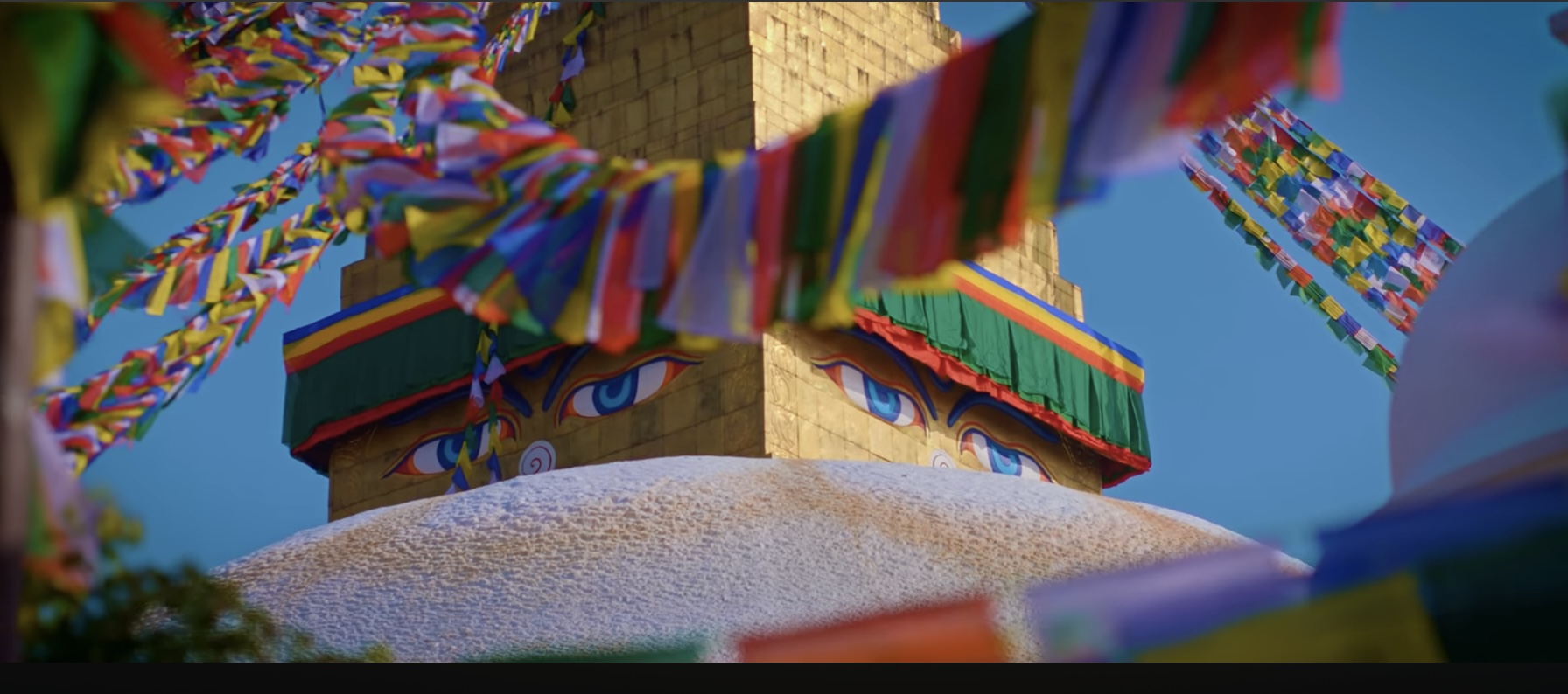 Buddha eyes on stupa with colorful prayer flags