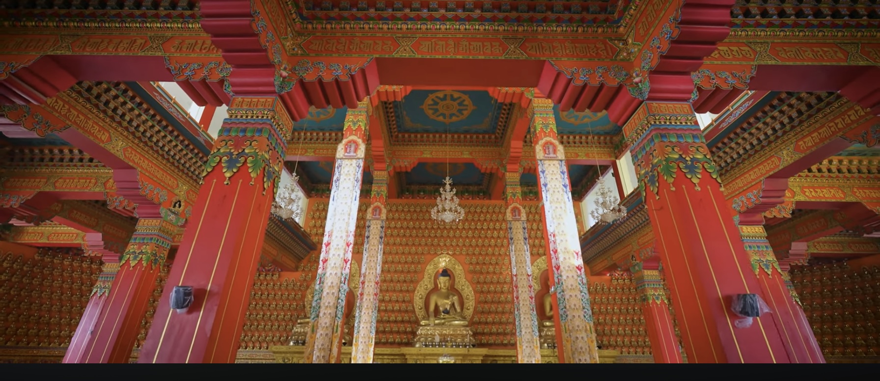 Ornate Buddhist temple interior with golden Buddha statue