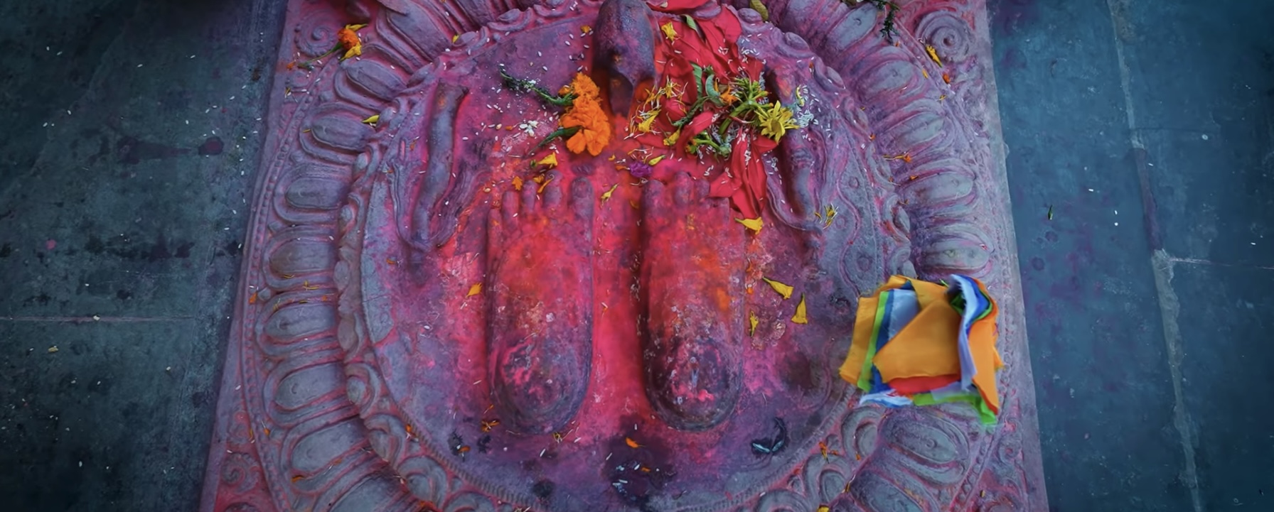 Sacred Buddha footprints with colorful offerings and prayer cloths