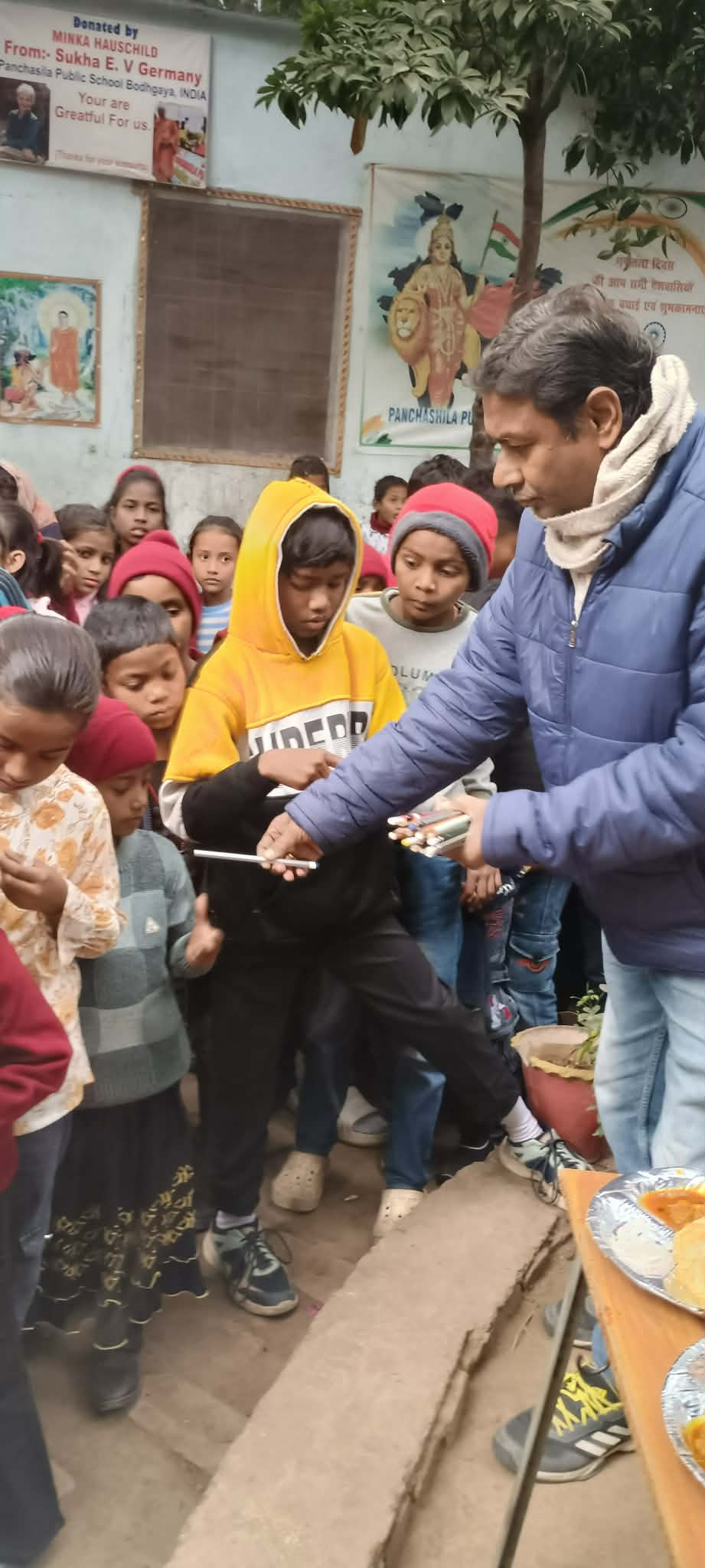 Village Traveler volunteer distributing school supplies to children at Panchsheel School in Bodhgaya